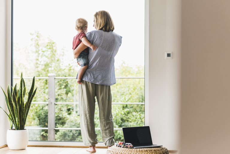 Mother carrying son, looking out of window